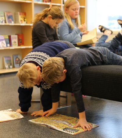 Elever som leser på biblioteket på Spangereid skole.